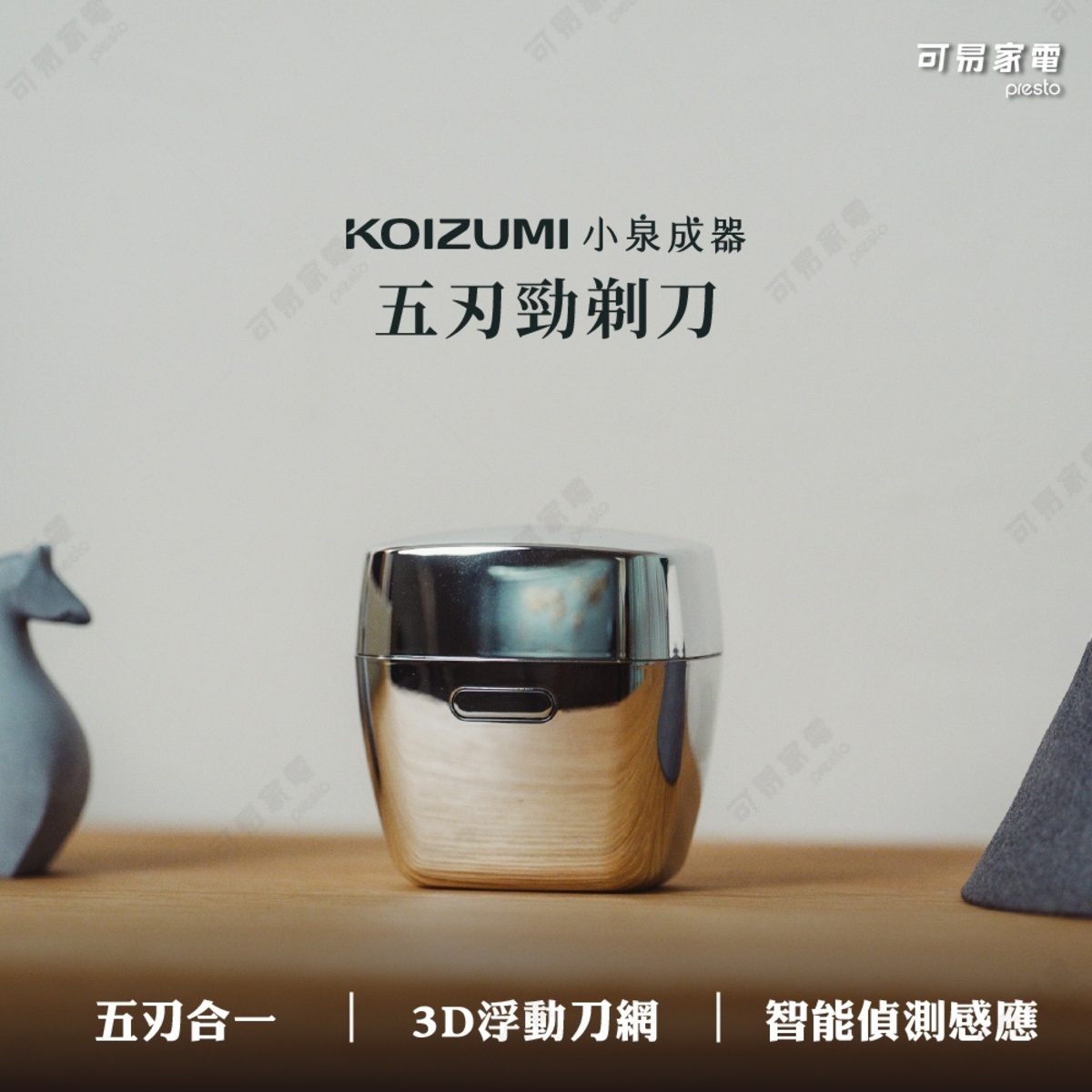 這是一款日本KOIZUMI小泉成器推出的五刃勁剃刀，產品主體呈現金屬質感的光滑外殼，置於木質桌面上。圖片下方標註產品具備五刃合一、3D浮動刀網以及智能偵測感應功能。