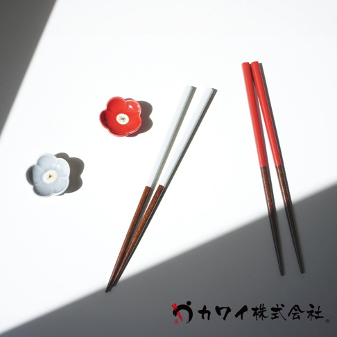 白色與紅色木筷各兩雙，搭配紅色及灰色花朵造型陶瓷盤。