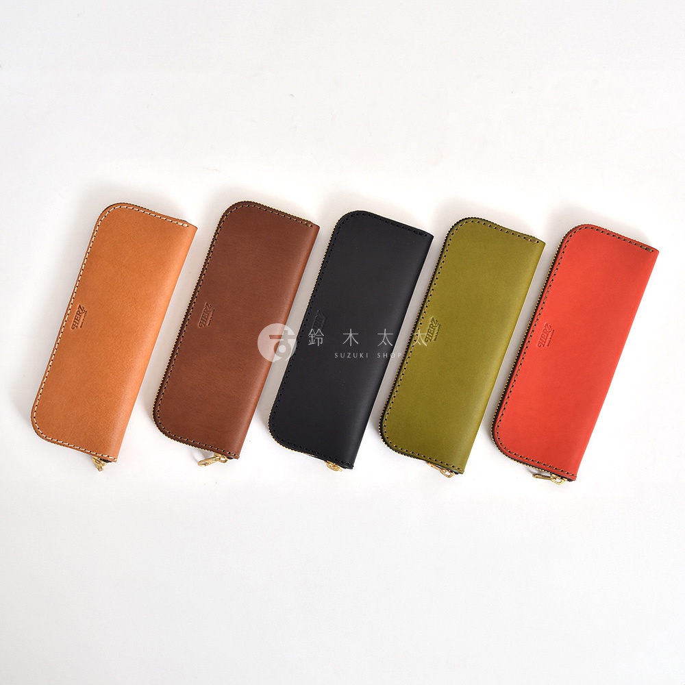 五個皮革筆袋，依序為橘褐色、深棕色、黑色、橄欖綠和紅色，皆有拉鍊開合。