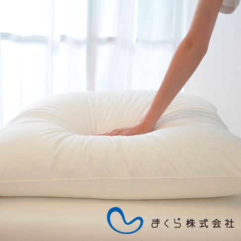 展示一個米白色方枕，表面柔軟，中央有一個由手臂壓出的凹陷，材質看來是光滑的布料。