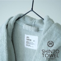 淺藍色 YUKINE 有機棉蓬厚浴袍，掛於黑色衣架上，衣領處有白色標籤，標示「ORGANIC COTTON 100%」及「SHINTO TOWEL, MADE IN JAPAN」。