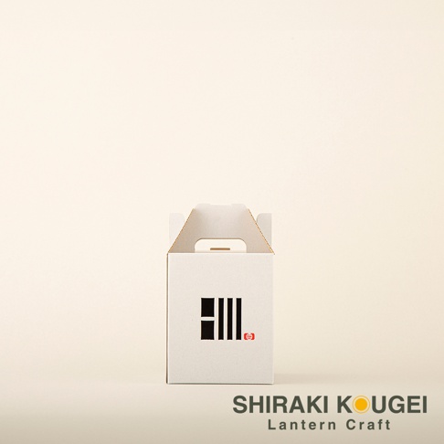 白色紙盒提燈，盒身正面印有黑色條紋圖案及紅色小印章。