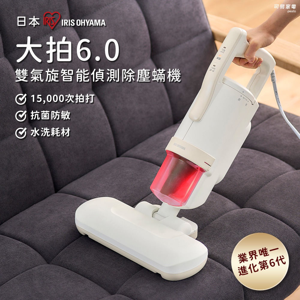 白色雙氣旋智能偵測除塵蟎機，配有透明紅色集塵筒，正在灰色布質沙發上運作。