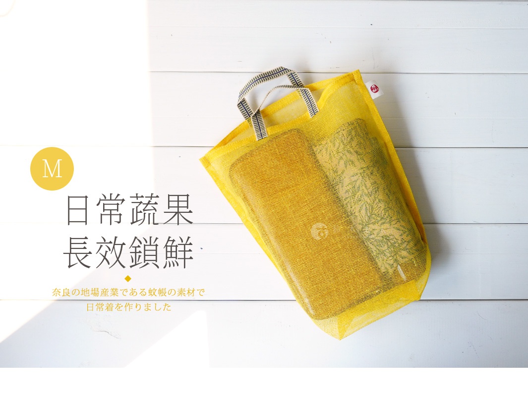黃色網狀提把蔬果收納袋，材質為透氣網布，袋內裝有綠色植物圖案的物品，尺寸標示為M。