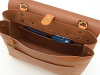 職人手作皮革雙扣三用後背包，採用棕褐色皮革材質，包身結構清晰，內部設有隔層，可放置手機等小物。金屬雙扣設計，增添復古質感。