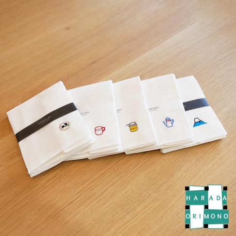 五條白色八重紗精繡萬用吸水擦拭巾，表面有細緻的格紋織紋。每條擦拭巾上繡有不同的圖案：一杯咖啡、一個茶杯、一罐果醬、一個茶壺，以及一座富士山。