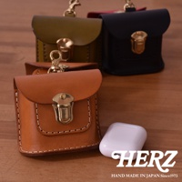 職人手作皮革耳機收納包，展示有棕褐色、橄欖綠、黑色和紅色等多種顏色，均配有金色金屬鎖扣和鑰匙圈。