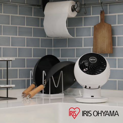 白色圓形IRIS OHYAMA 空氣循環扇，黑色扇網，底部為白色圓盤底座，擺放在廚房檯面上。