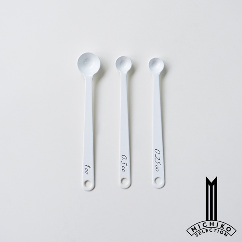 視覺描述模式： 三支白色琺瑯計量匙，從左至右分別標示著 1cc、0.5cc 和 0.25cc，其中一支附有品牌標誌。
