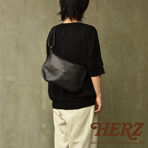 職人手作皮革Organ單肩半月包，黑色，光滑皮革材質，半月形包身，肩帶可調節，搭配金色金屬扣件，由後方展示。