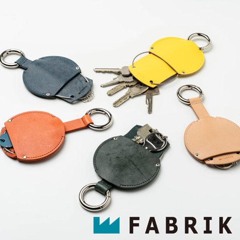 FABRIK 皮革圓型收納鑰匙圈，共有藍色、橘色、綠色、黃色和裸色五款，展示於白色背景上，其中黃色款可見多把鑰匙。