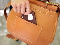 職人手作皮革屋瓦風迷你後背包 (R-6)，採用天然棕色皮革，搭配明線縫製，正面有一個方形外袋，袋口處印有「HERZ」品牌標誌。