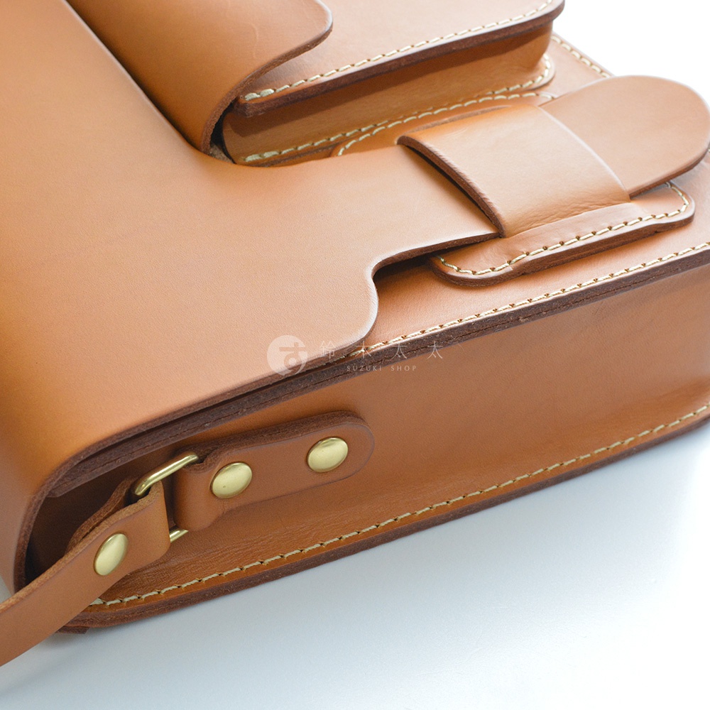 職人手作皮革單肩包，採用經典厚實的棕褐色皮革，縫線精緻，附有銅製金屬釦和皮帶扣。