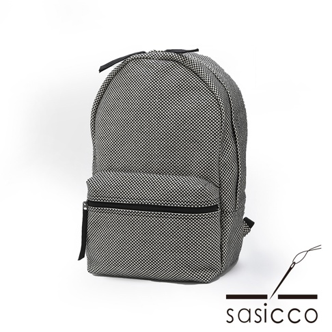 三河木綿刺子織後背包，採用經典的黑白格紋圖案，材質厚實耐磨，主體為圓潤的造型，正面有一個拉鍊口袋，搭配黑色拉鍊與揹帶。