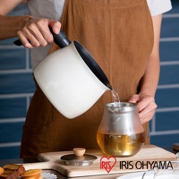 象牙白色鑽石不沾單柄小湯鍋，鍋內為黑色不沾塗層，黑色防滑手柄。一人正在將鍋中液體倒入玻璃茶壺。