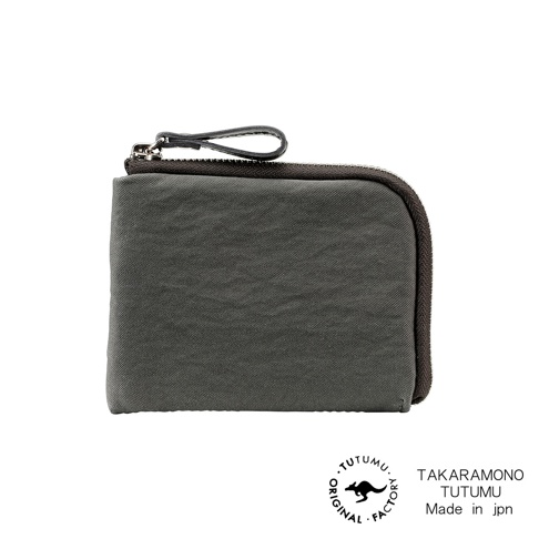 一個炭灰色的迷你拉鍊錢包，有深棕色的拉鍊和一個連接的皮環。包包的左下方有「ORIGINAL . TUTUMU . FACTORY」的圓形標誌，裡面有一個剪影袋鼠圖案。右下方有「TAKARAMONO TUTUMU Made in jpn」的文字。