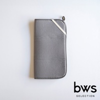 灰色可折疊收納瀝水墊，表面有細小的網狀紋理，邊緣為深灰色，一側配有米白色綁帶和掛環。