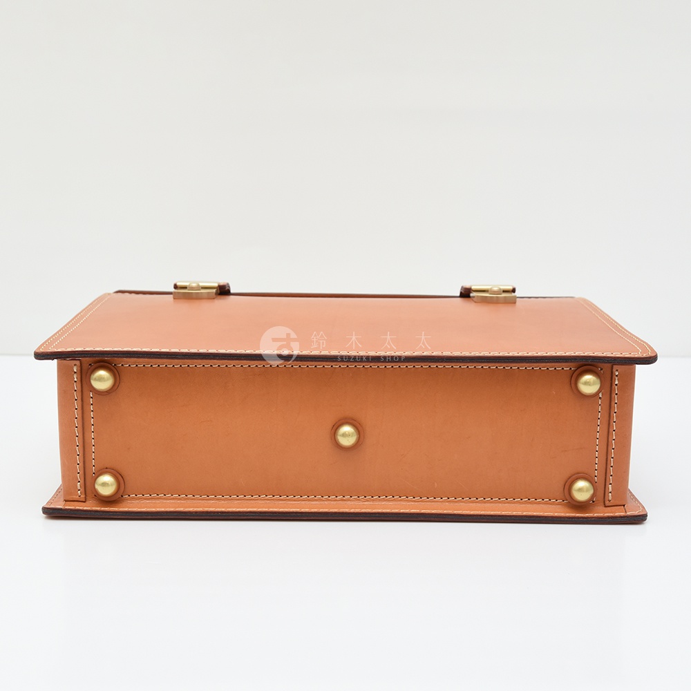 職人手作皮革機師箱 BC-31，淺棕色皮革，箱體側面飾有黃銅铆釘和鎖扣，線條簡潔，縫線工整。