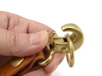 職人手作皮革旋轉扣鑰匙圈，採用黃褐色皮革製成，搭配黃銅色旋轉扣和掛環，展現復古質感。