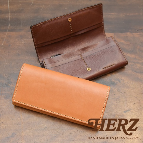 兩個職人手作皮革長夾，一個為淺棕色、一個為深棕色，皆為軟皮材質，搭配車縫線和金屬釦，展現簡約設計。