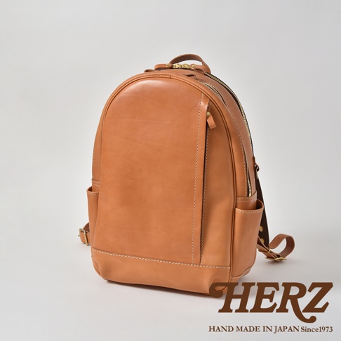 職人手作皮革多功能後背包 R-21，採用天然棕色皮革製成，設計簡約，配有雙拉鍊主隔層、前方拉鍊口袋及側邊收納袋，適合日常攜帶。