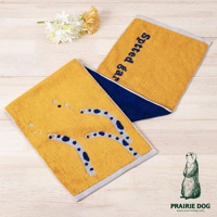 兩條黃色運動毛巾，其中一條印有藍色動物腳印刺繡圖案，另一條繡有藍色日文「spotted gar」。兩條毛巾均有深藍色和淺灰色滾邊。