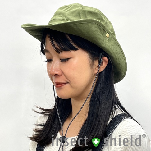 一名女性戴著一頂軍綠色寬簷漁夫帽，帽緣有兩個黃銅扣，帽側有黑色編織繩索固定。