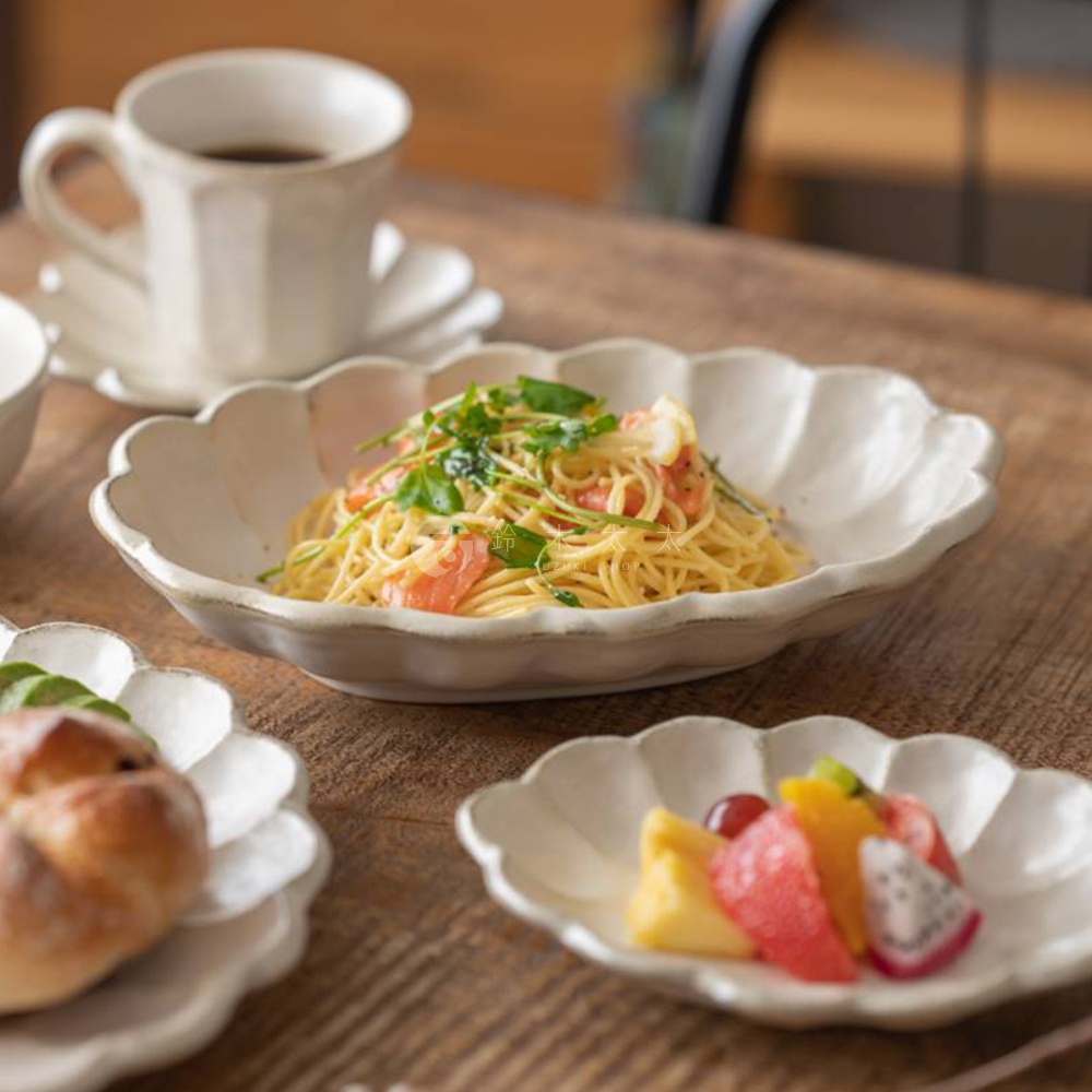 六魯粉引花型橢圓料理盤，盛裝著義大利麵，盤緣帶有花瓣狀的白色陶瓷，整體呈現樸實的日式風格。