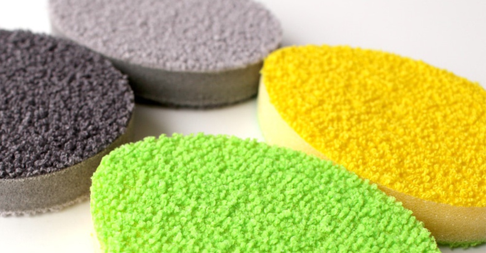 一套有灰色、綠色和黃色三種顏色的圓形菜瓜布，材質表面有顆粒感，側面是白色海綿。