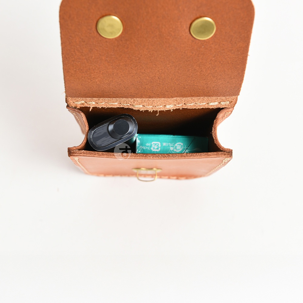 職人手作皮革經典腰袋，淺棕色牛皮材質，配有金屬釦，袋內裝有電子菸及薄荷糖盒。