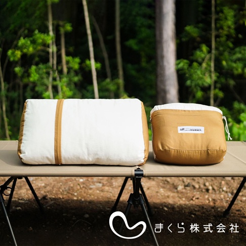 JOURNEY 旅行便攜枕，一個展開的白色枕頭，側面有兩條淺棕色織帶；旁邊是一個收納袋，淺棕色外層印有「Life is a good JOURNEY.」字樣，頂部露出白色枕頭。