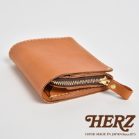 棕色皮革雙折短夾，拉鍊開合，配有同色皮革拉袢。車縫線清晰可見，質感細膩。