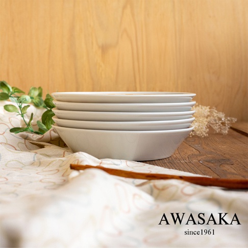 一疊五個白色、帶有淺弧度的陶瓷甜點配菜盤，盤面簡潔無花紋，擺放在有著復古線條圖案的淺色布料上，背景為木質紋理。