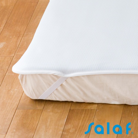 SALAF COOL 極致涼感透氣單人睡墊，白色網眼格紋表層，搭配米色邊緣及固定鬆緊帶，放置於淺棕色木地板上。