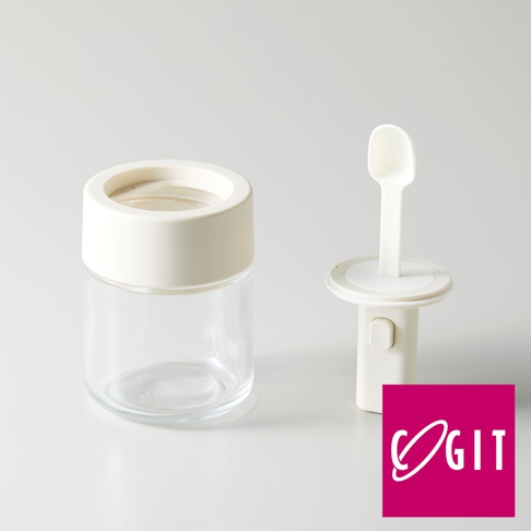 一個透明玻璃罐，搭配米白色蓋子，旁邊是一個米白色的一鍵伸縮量匙裝置，量匙為白色。