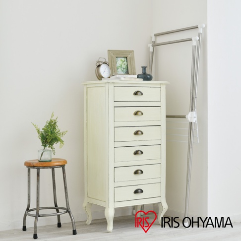 淺米色六層抽屜櫃，帶有復古風格的抽屜把手，搭配銀色金屬支架曬衣架。