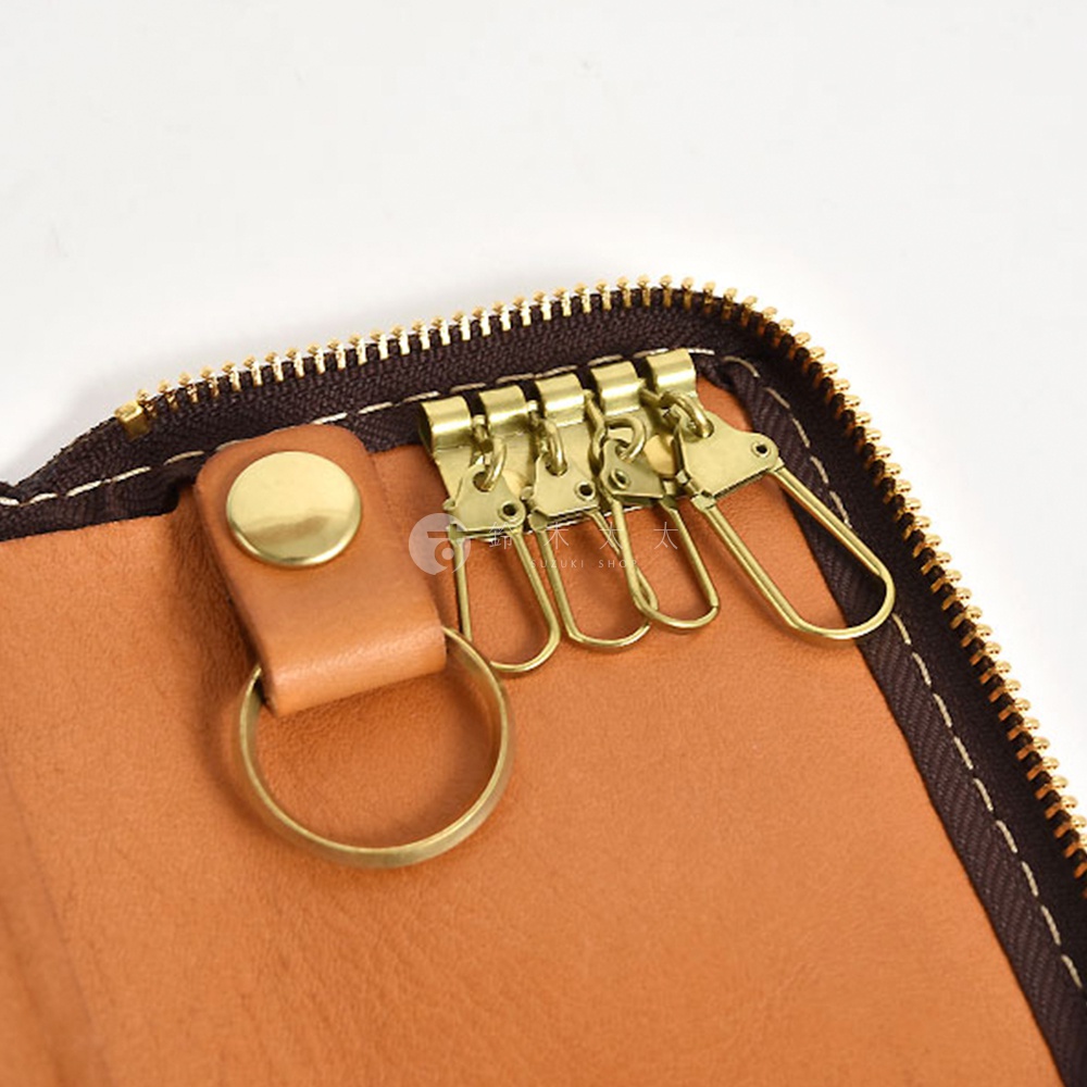 棕色皮革鑰匙包，內有四個金色掛鉤和一個金色圓環。