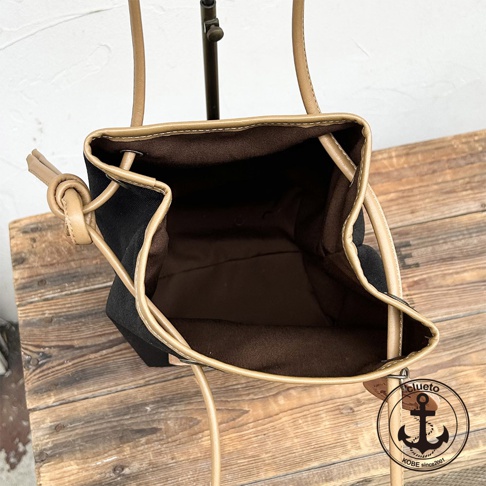 神戶clueto防潑水尼龍束口肩背包的內部，展示了黑色尼龍內襯和淺棕色皮革飾邊。