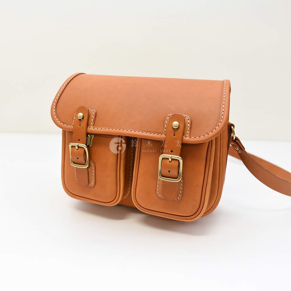 日本HERZ職人手作皮革經典雙扣郵差包 CK-100，採用棕色Latigo硬皮革製作，設有雙前袋與金屬扣具。