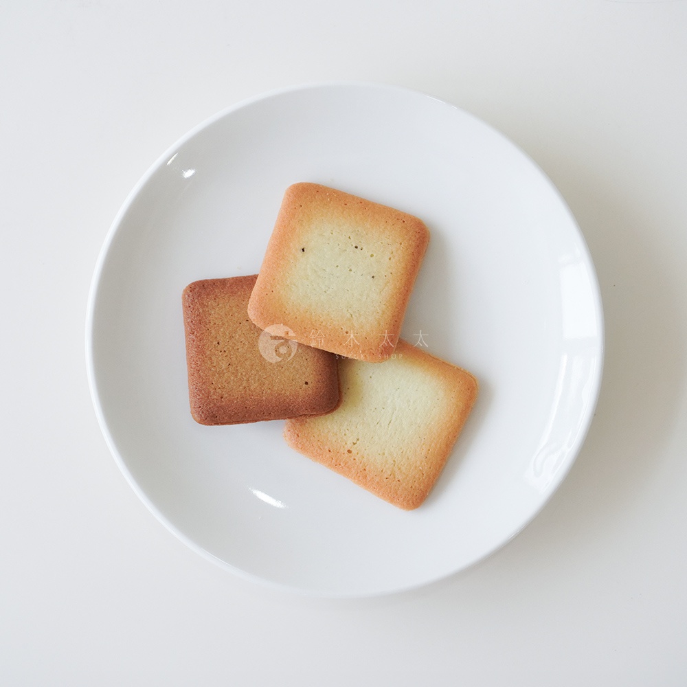 盤子上有三塊方形餅乾，其中兩塊是淺黃色，一塊是深棕色。