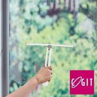 一支白色的360度磁吸旋轉刮水刷，由塑膠材質製成，手柄部分為白色，刮頭為白色，正用於清潔佈滿水珠的玻璃窗。