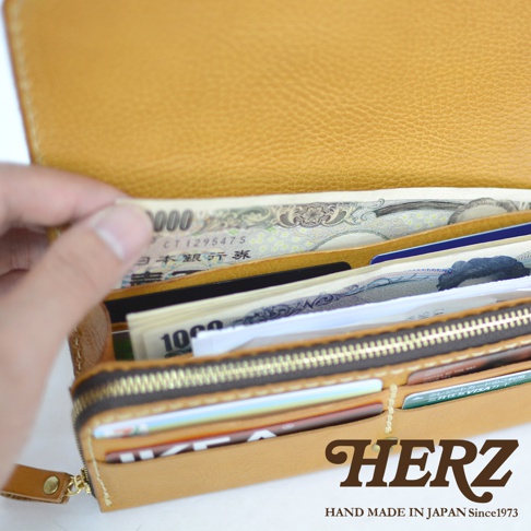 職人手作皮革長夾，黃褐色，內部裝有日圓鈔票與多張信用卡，展示寬口設計與大容量收納空間。