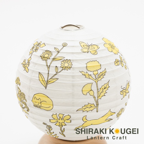 紙製圓形提燈，白色燈籠上繪有黃色線條勾勒的花卉、蝴蝶、睡貓與奔跑的狐狸圖案，下方標有「SHIRAKI KOUGEI Lantern Craft」。