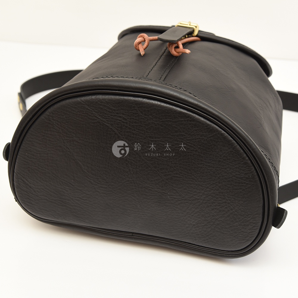 黑色皮革束口後背包，頂部有單扣設計與繫繩，皮革質感，無 Logo 顯示。