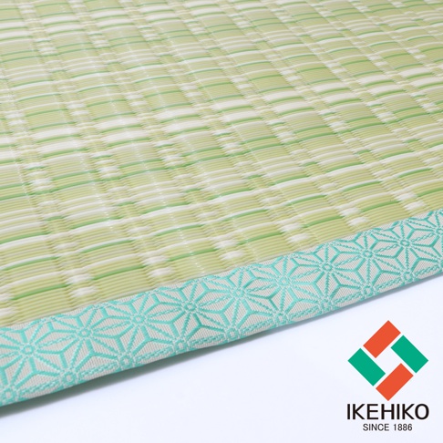 水洗PP榻榻米風格地墊，以淺綠色與白色交織的編織紋理為主體，邊緣飾有淺藍色幾何圖案滾邊，展現日式簡約風格。