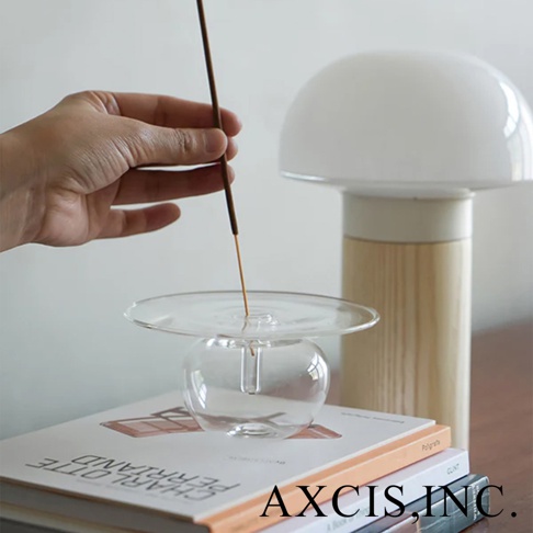 Lua 多功能線香玻璃花器，由 AXCIS Inc. 出品，左手持線香，上方是白色蘑菇造型燈。