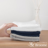 疊放的今治純棉毛巾，包含白色、海軍藍和灰色。毛巾表面有細緻的菱紋質感。