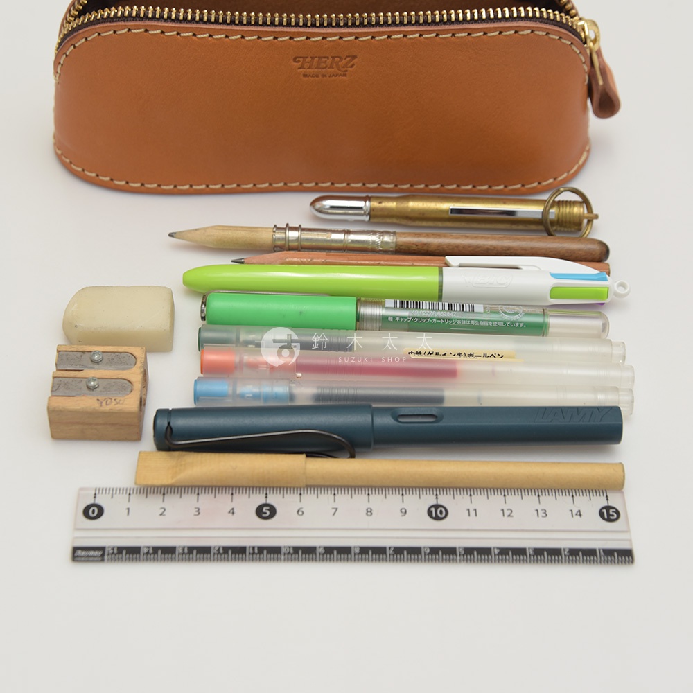 駝色皮革筆袋，內含鉛筆、綠色筆、藍色筆、鋼筆、橡皮擦、削筆器和尺。