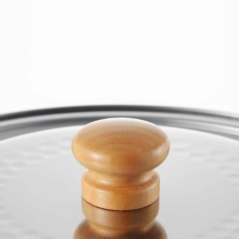 不鏽鋼鍋蓋中央設有一個圓形木質把手，鍋蓋表面有紋理，邊緣為金屬。