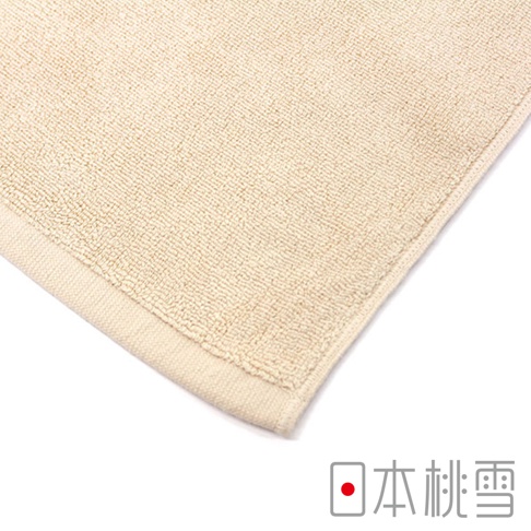 淺米色毛圈織紋浴墊，邊緣有細膩的包邊。